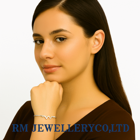 "Close-up of a woman wearing a delicate bracelet with a polished silver-tone M-shaped or wave-shaped charm at the center.
