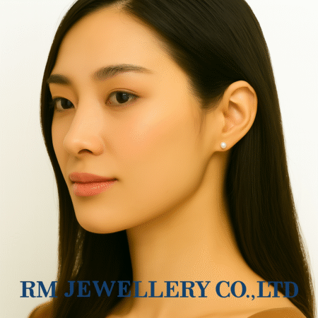 "Close-up profile of a woman wearing small, round, white pearl stud earrings.