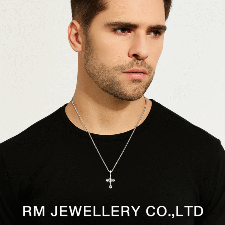 "Man wearing a silver-tone necklace with a small, detailed cross pendant hanging from a fine chain on a black shirt